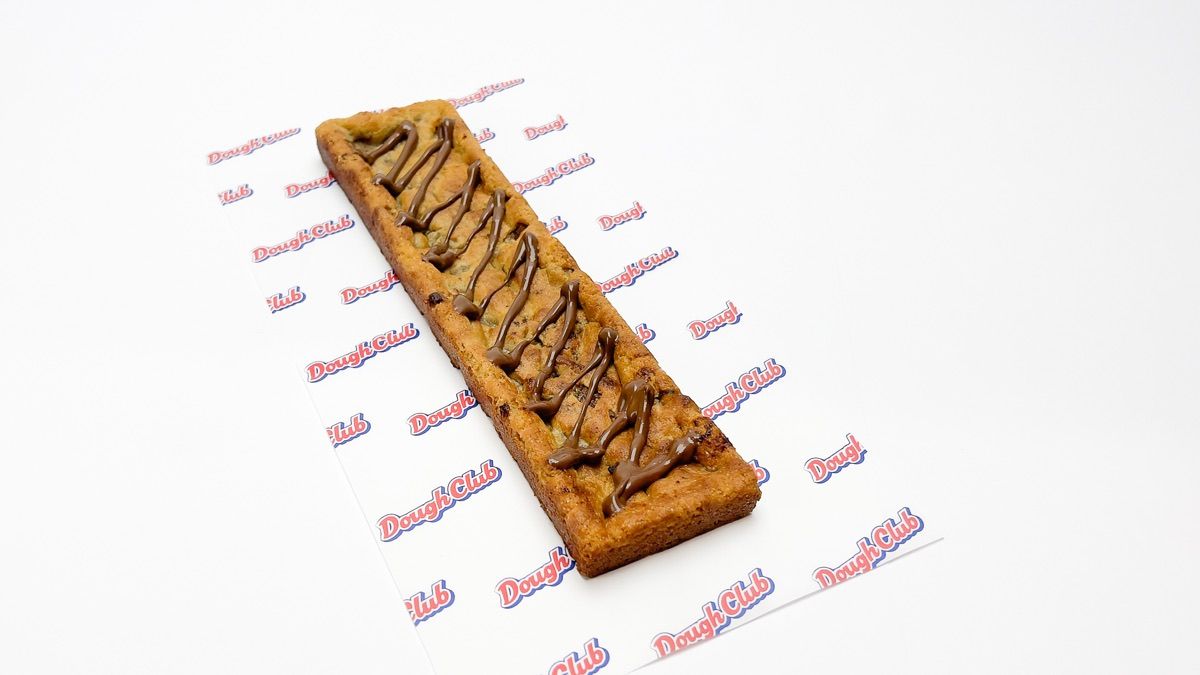 A Dough Club cookie, freshly baked and finished with chocolate hazelnut sauce