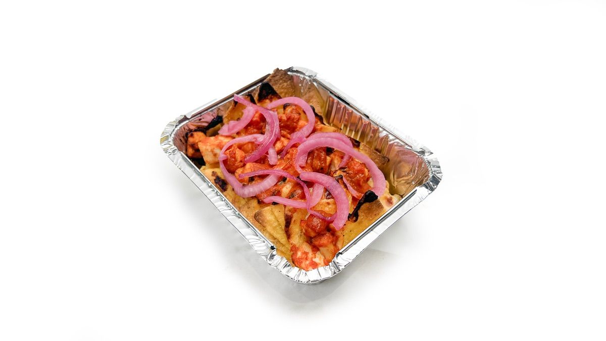 A tray of Dough Club nachos topped with butter chicken and pickled red onions