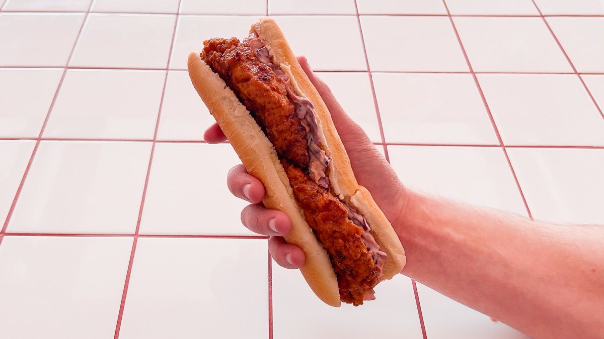 A Dough Club Hot Honey Tender sub, held in one hand