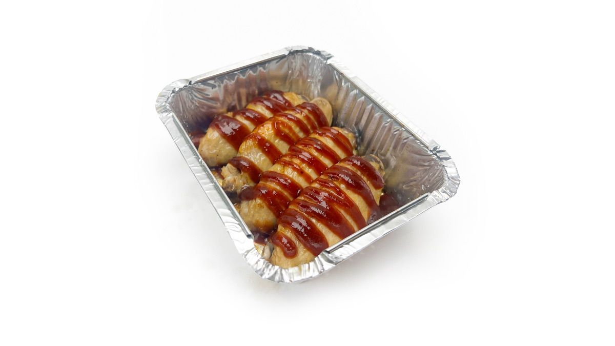 A tray of Dough Club baked chicken wings drizzled with BBQ sauce